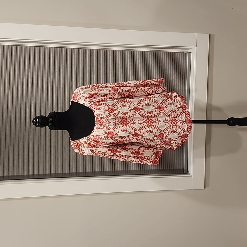 Red and white embroidered shirt. Three quarter length sleeve.